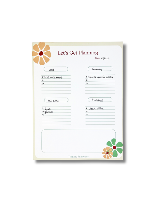 Planning notepad with floral designs on a white background
