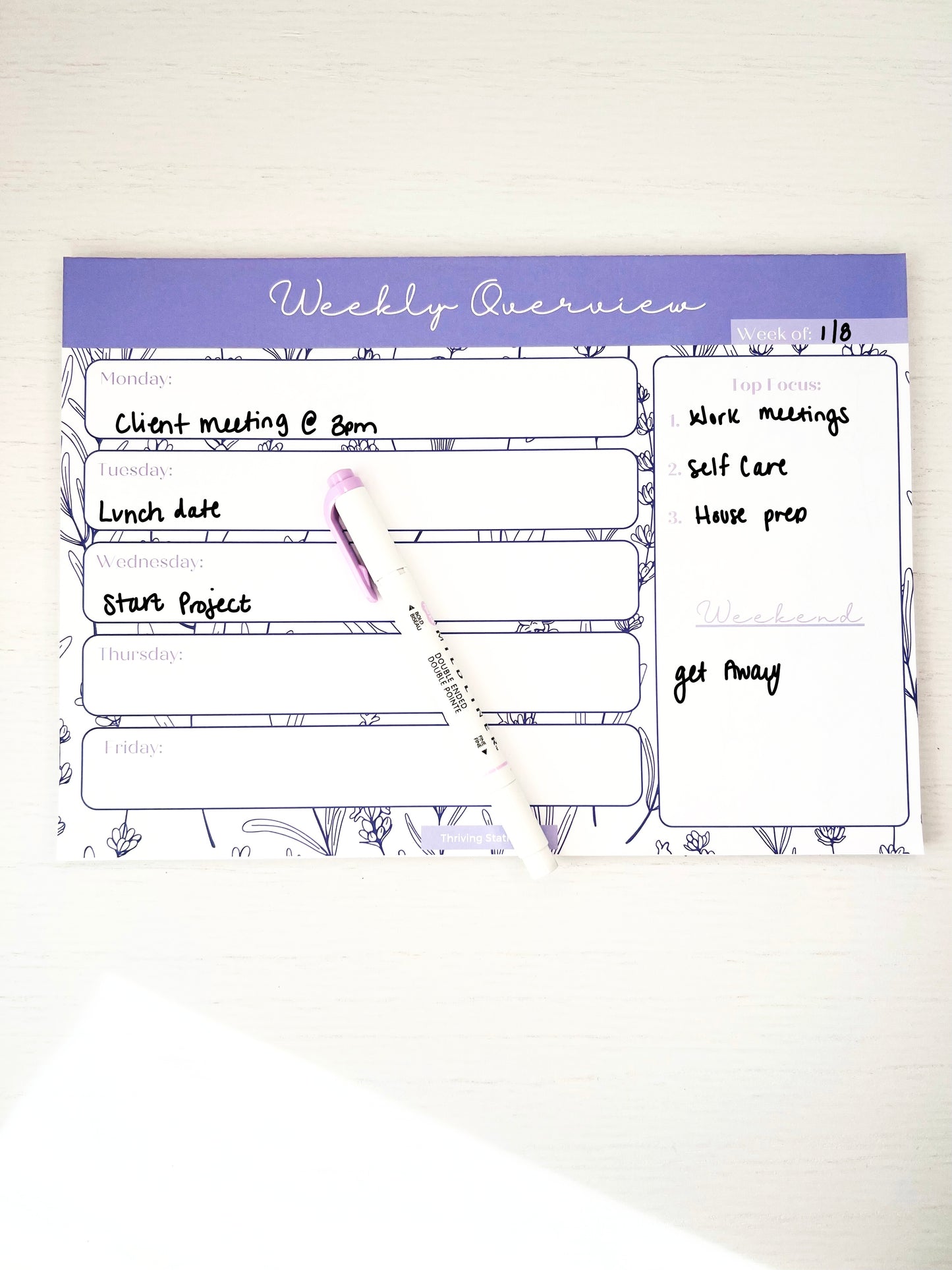 Lavender floral weekly planner notepad featuring daily sections, top 3 priority list, and weekend space on a white background.