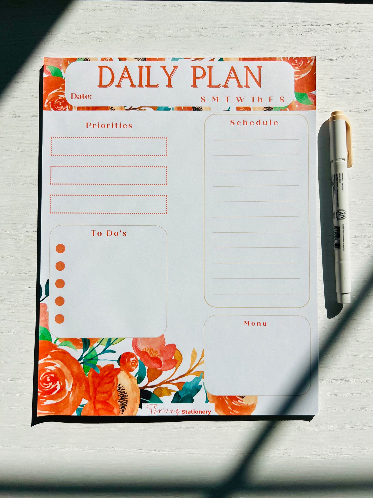 Stationery flat lay featuring red floral daily planner