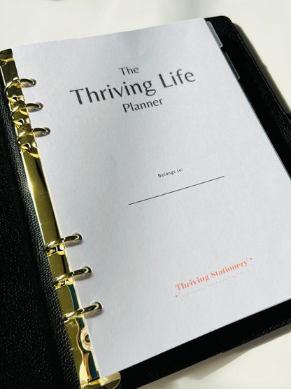 Thrive Life Planner with gold binding on a white background