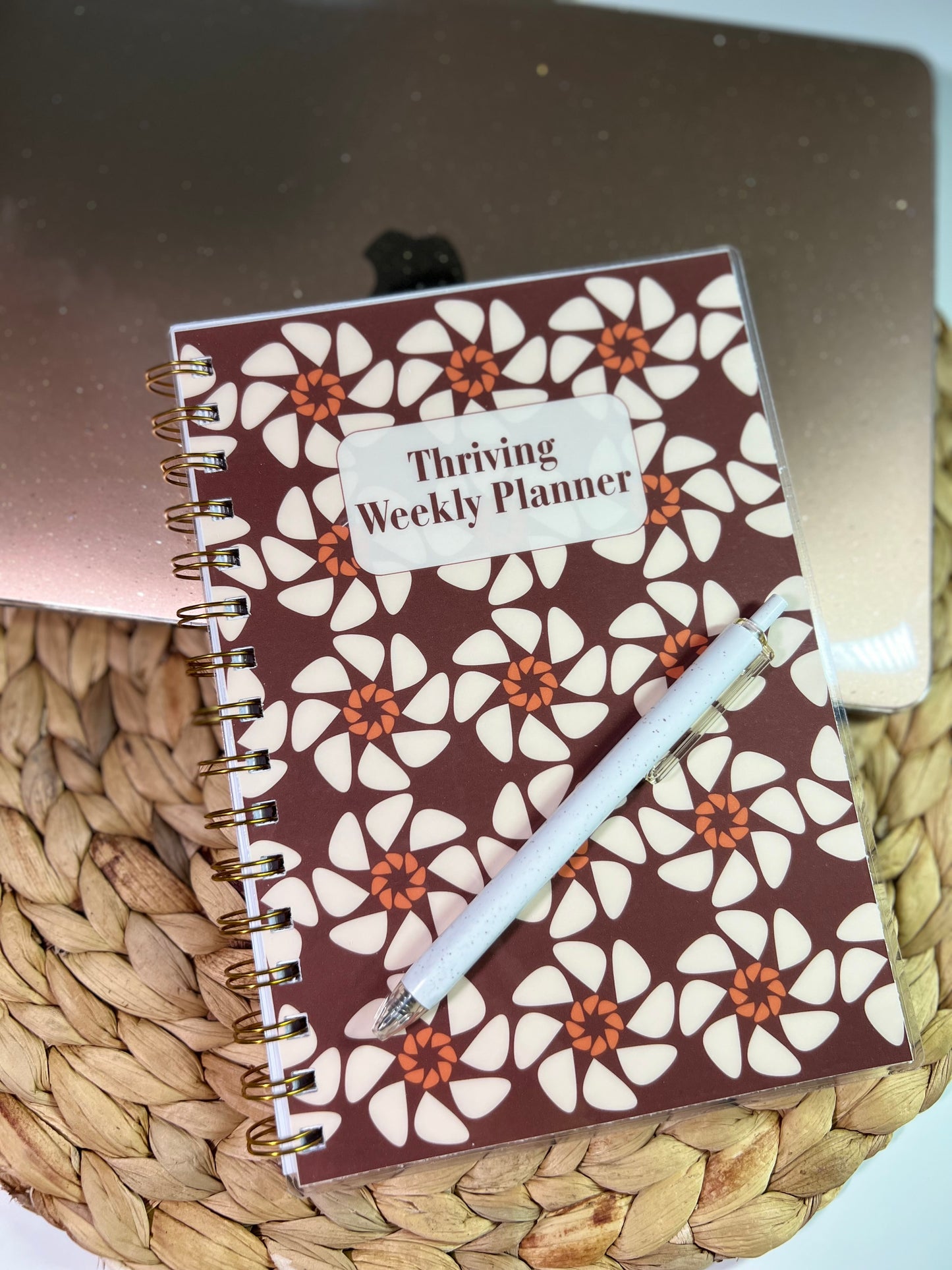 Weekly planner with floral design on a woven surface