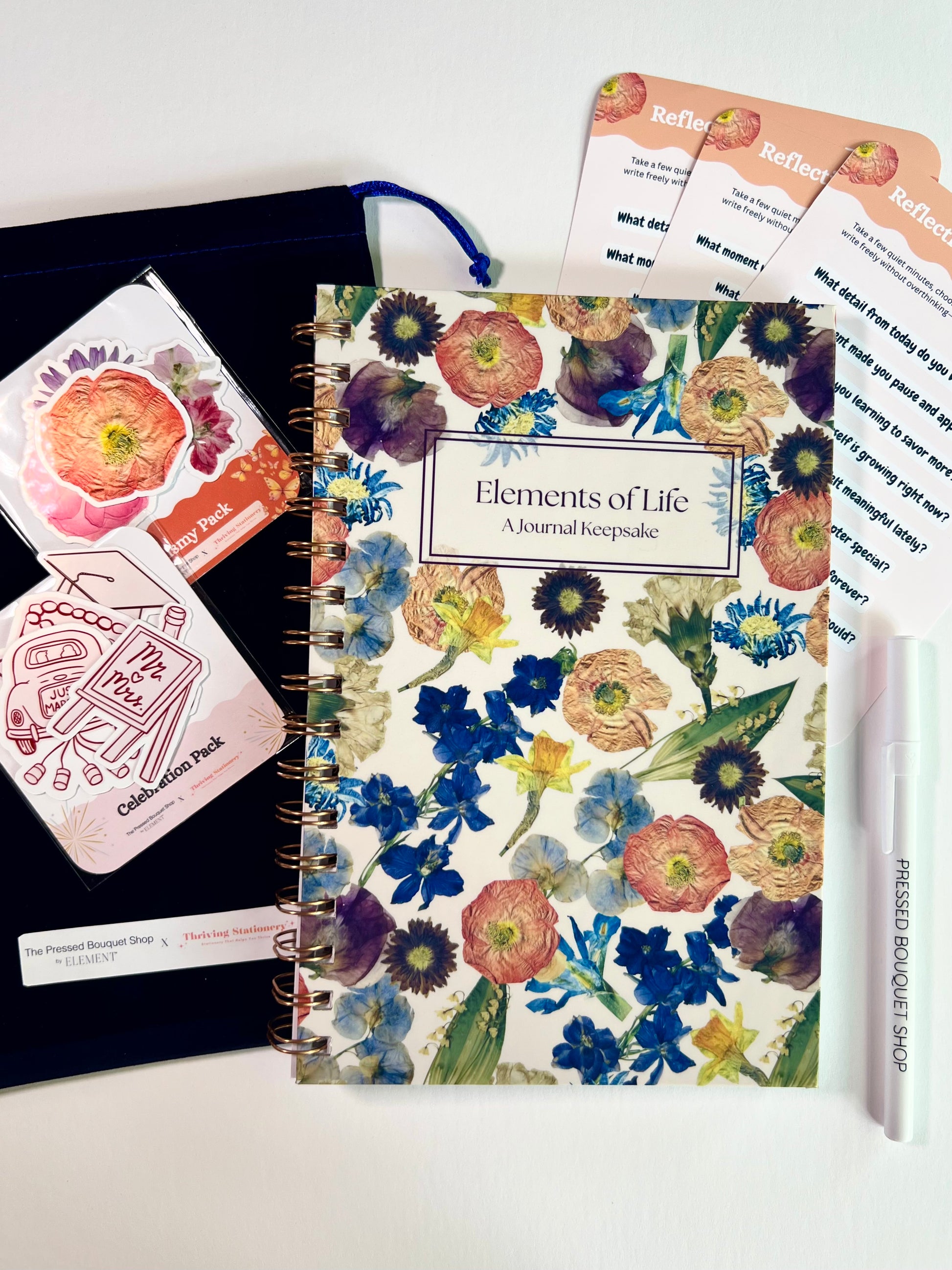 Floral notebook with stationery items on a white background