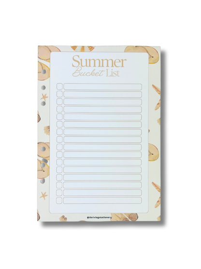 Notepad with 'Summer Bucket List' text and beach-themed border on a white background