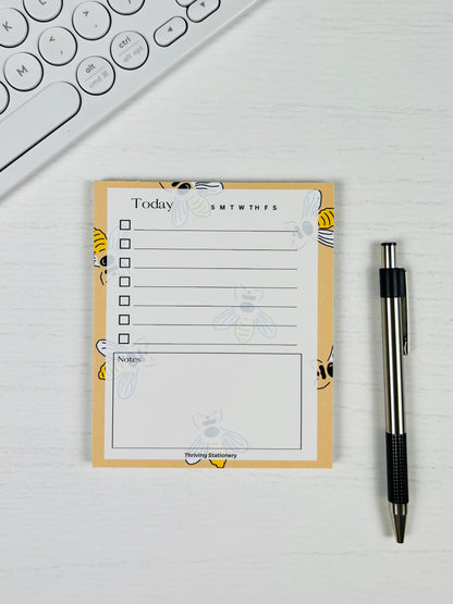 Bee Productive To-Do List Notepad with yellow bee design and daily checklist layout with pen for scale