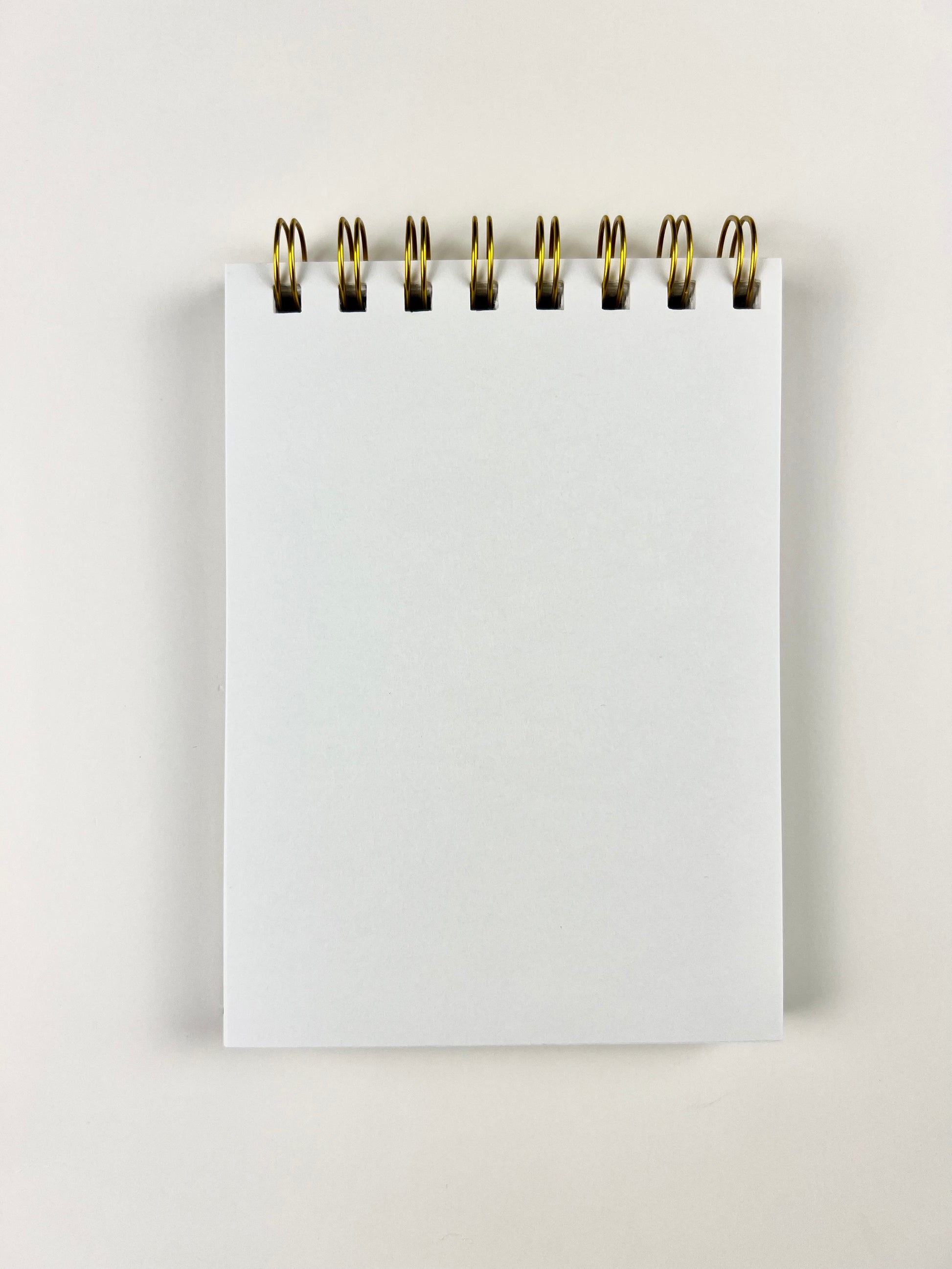 White spiral-bound notebook on a light gray background