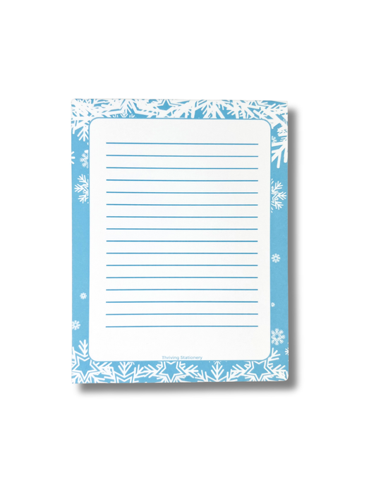 Notepad with blue floral border and lined pages on a white background