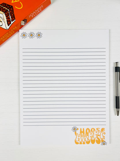 Notepad with decorative text and flowers, pen on Choose Happy Large Lined Notepad with cheerful text design and lined pages white background