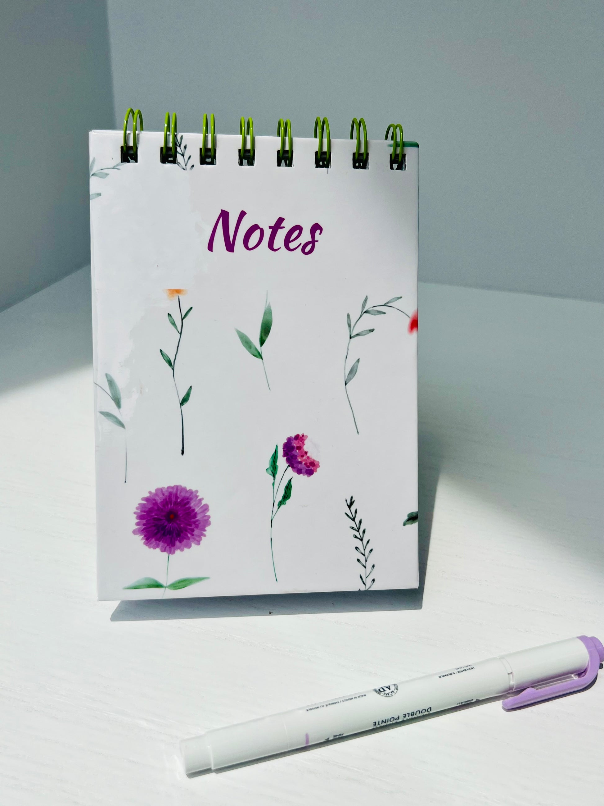 Mini floral top-bound notepad with delicate watercolor flowers and green spiral binding, perfect for note-taking, lists, and everyday writing.