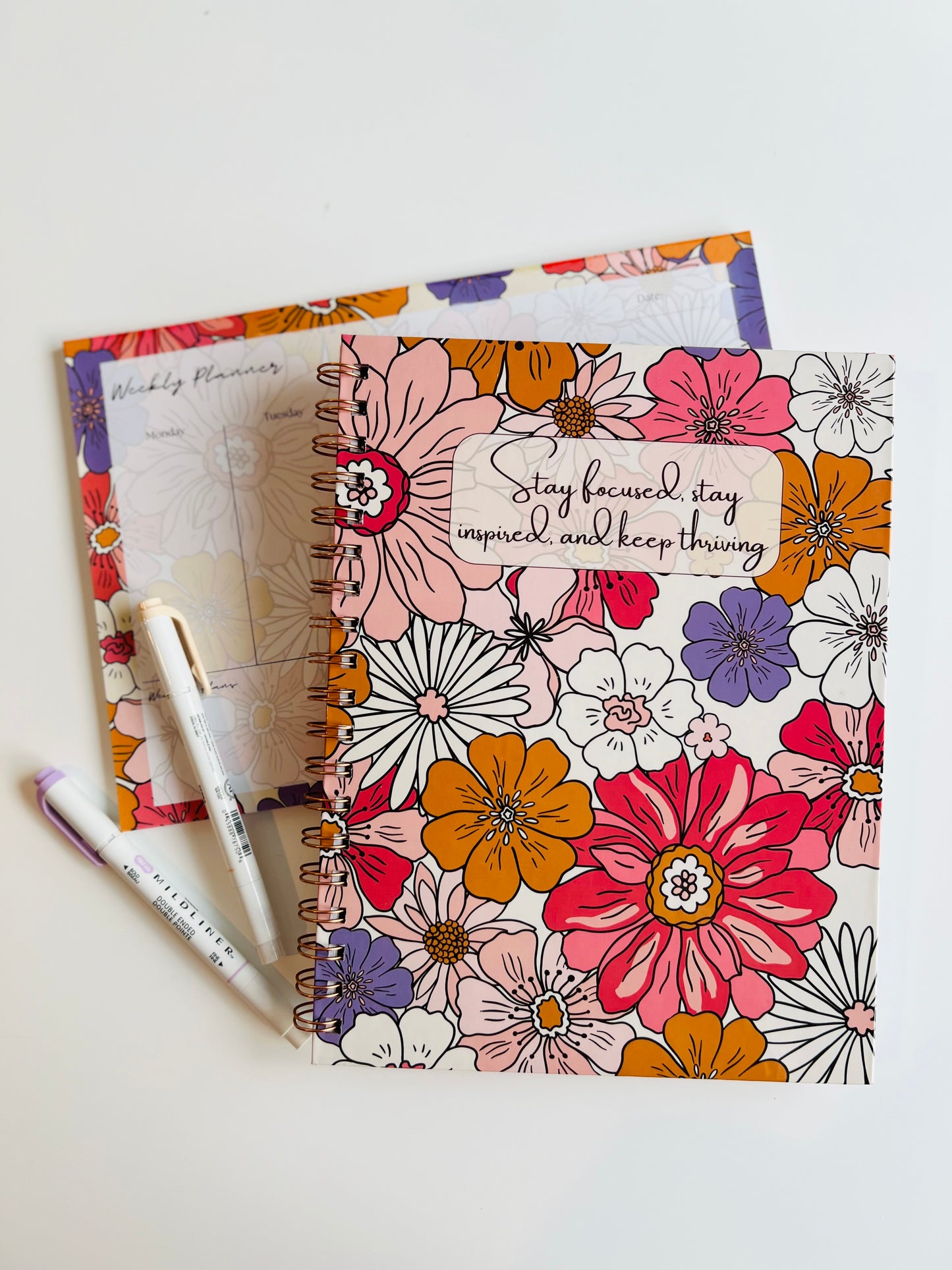 Spiral notebook with bold retro floral cover and motivational quote 'Stay focused, stay inspired, and keep thriving' – 120 double-sided lined pages by Thriving Stationery