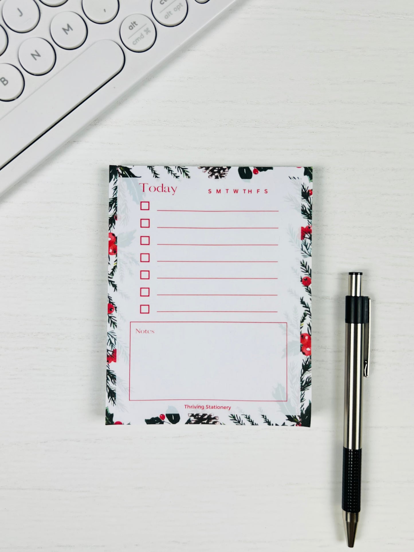 Floral notepad with a pen on a white surface