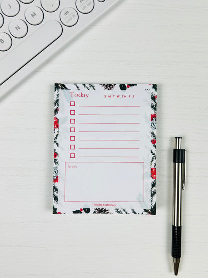 Floral notepad with a pen on a white surface