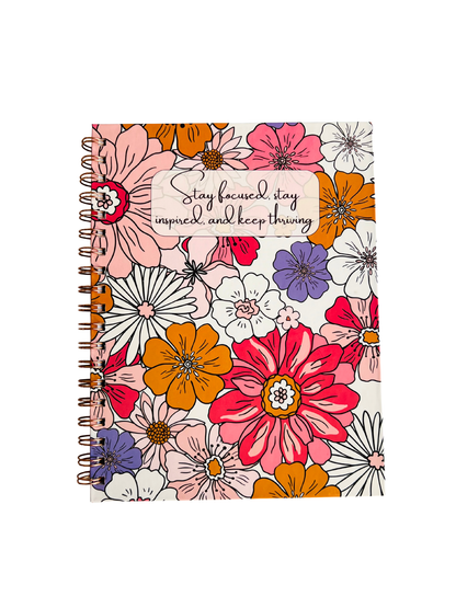 Floral notebook with motivational quote on a white background