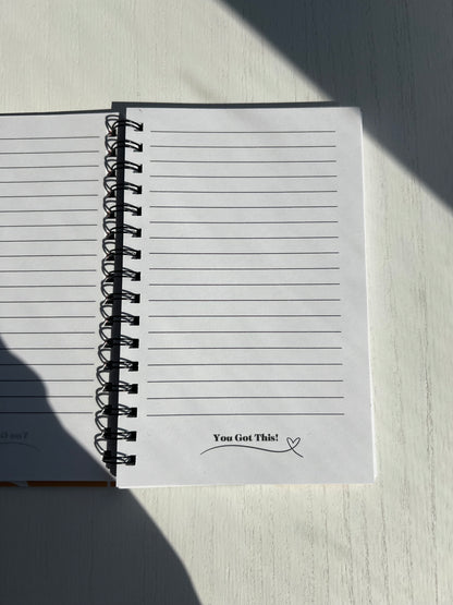 Spiral notebook featuring a bold retro orange and green floral cover with 115 double-sided lined pages from Thriving Stationery.