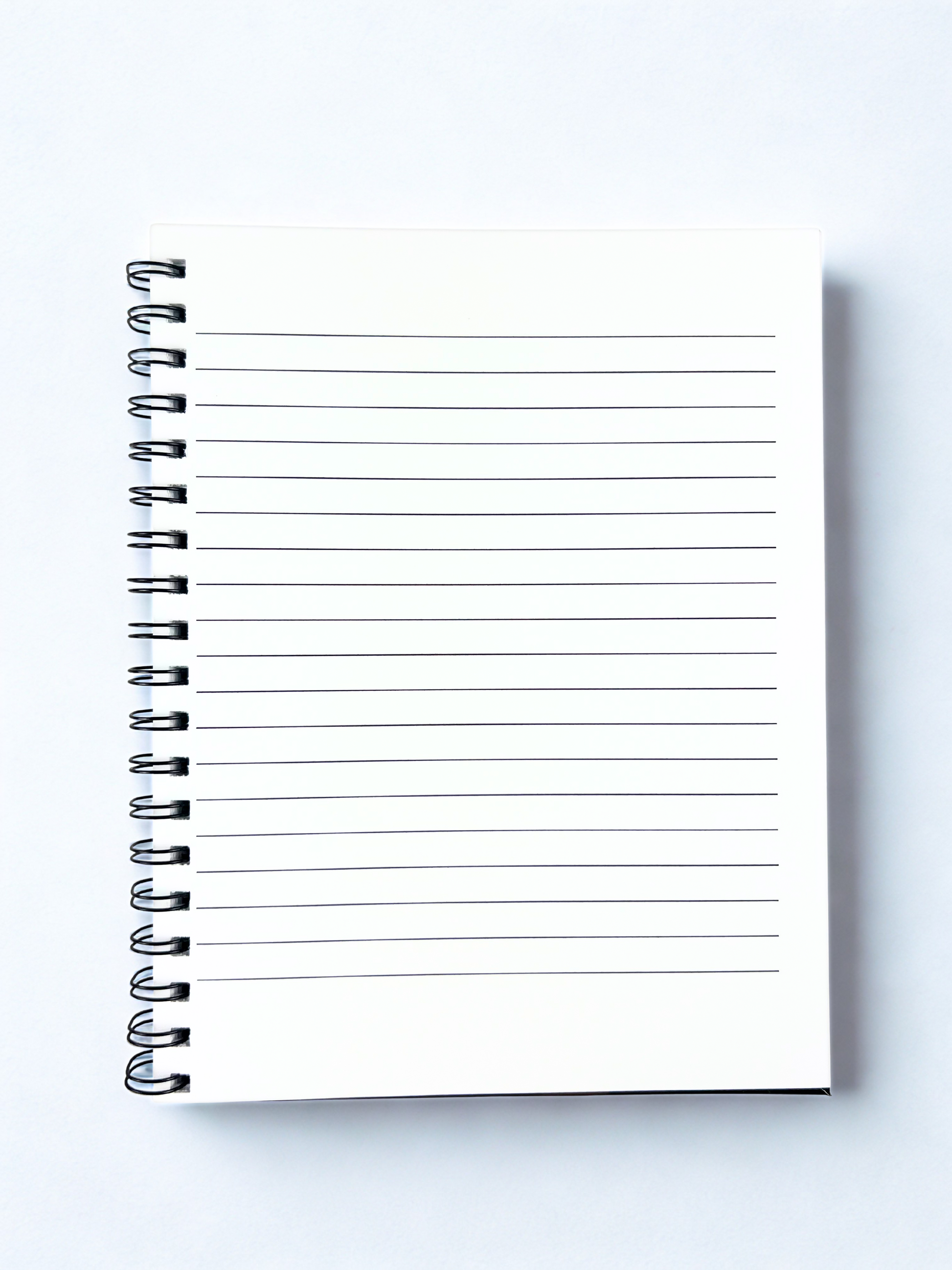 Spiral-bound notebook with lined pages on a white background