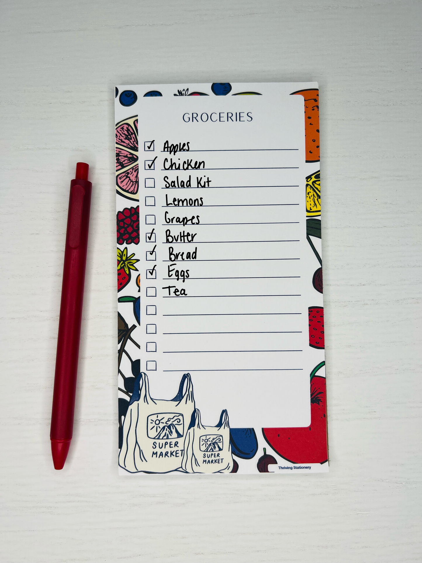 Magnetic grocery list notepad with colorful fruit illustrations, checklist lines, and Super Market tote bag design at the bottom.
