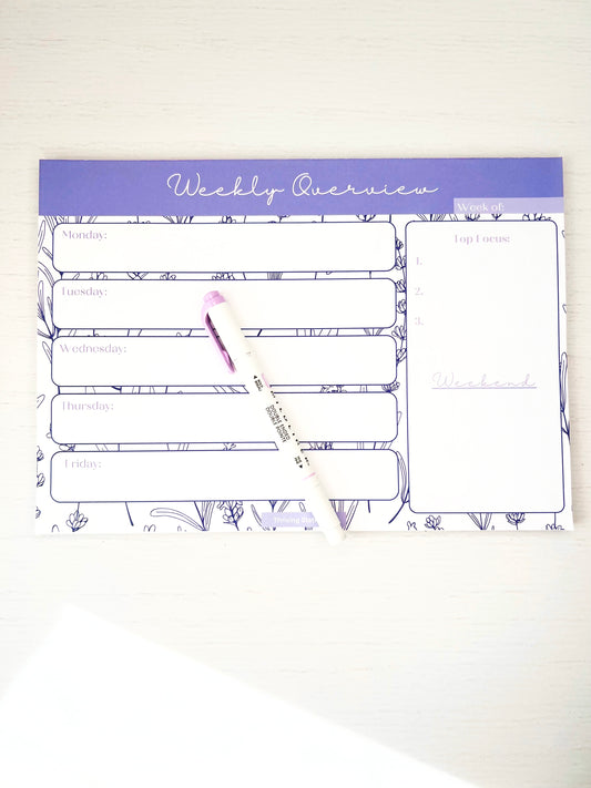 Lavender floral weekly planner notepad featuring daily sections, top 3 priority list, and weekend space on a white background.