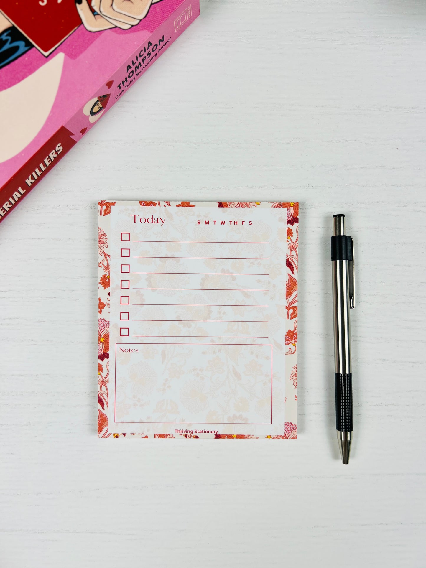 Roses in Bloom To-Do List Notepad with pink rose floral design and daily checklist layout with book and pen for scale