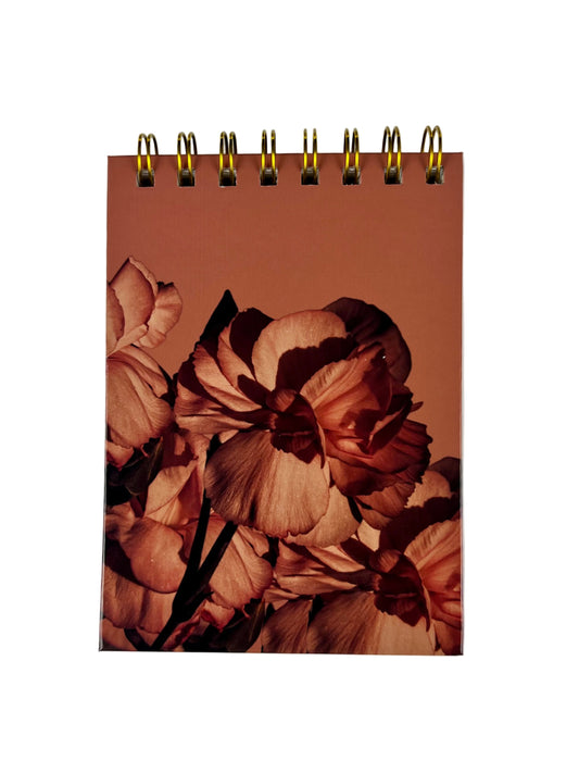 Notebook with floral design on a plain background