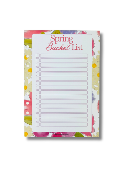 Notepad with 'Spring Bucket List' on a floral patterned background