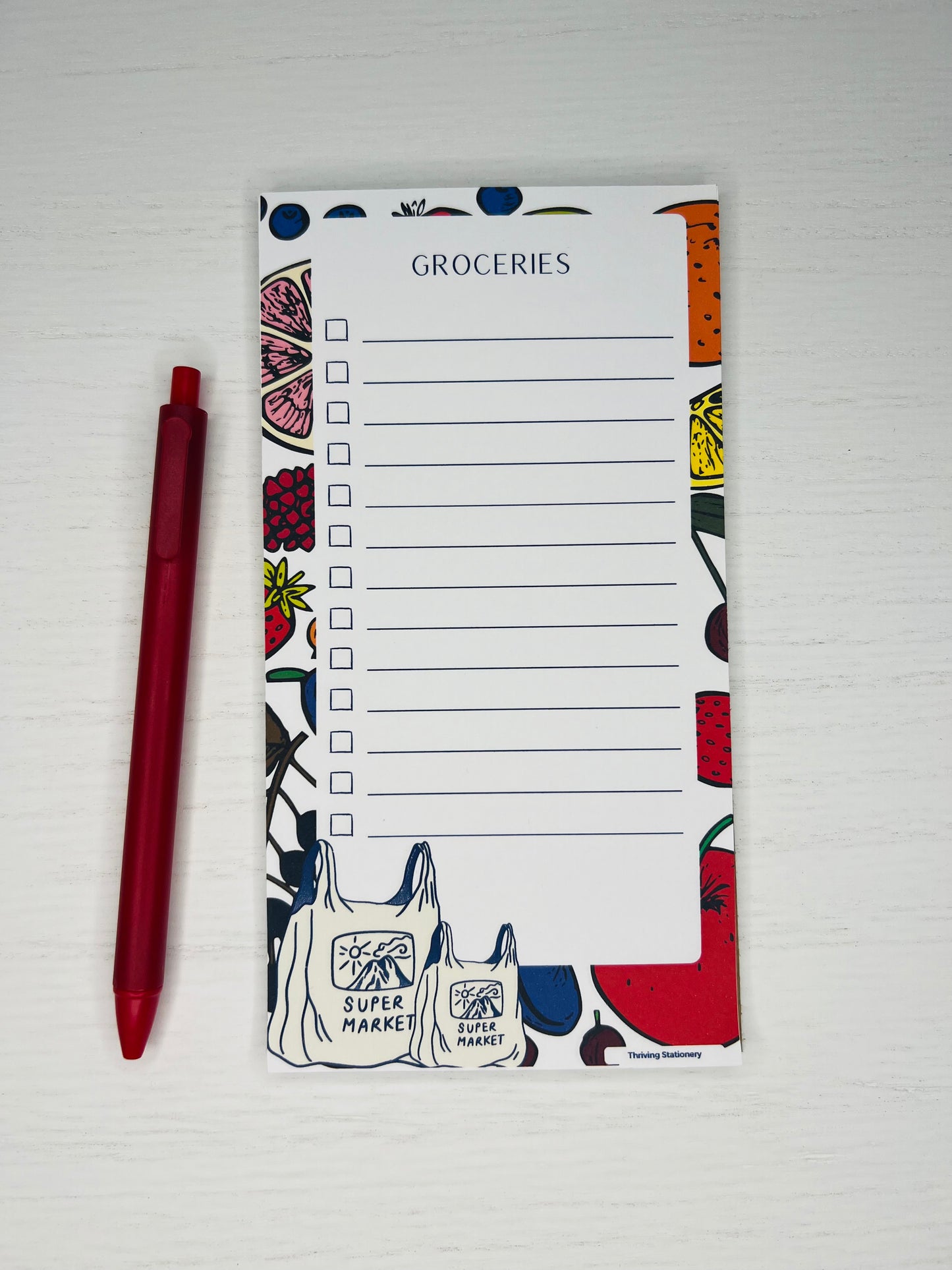 Magnetic grocery list notepad with colorful fruit illustrations, checklist lines, and Super Market tote bag design at the bottom.