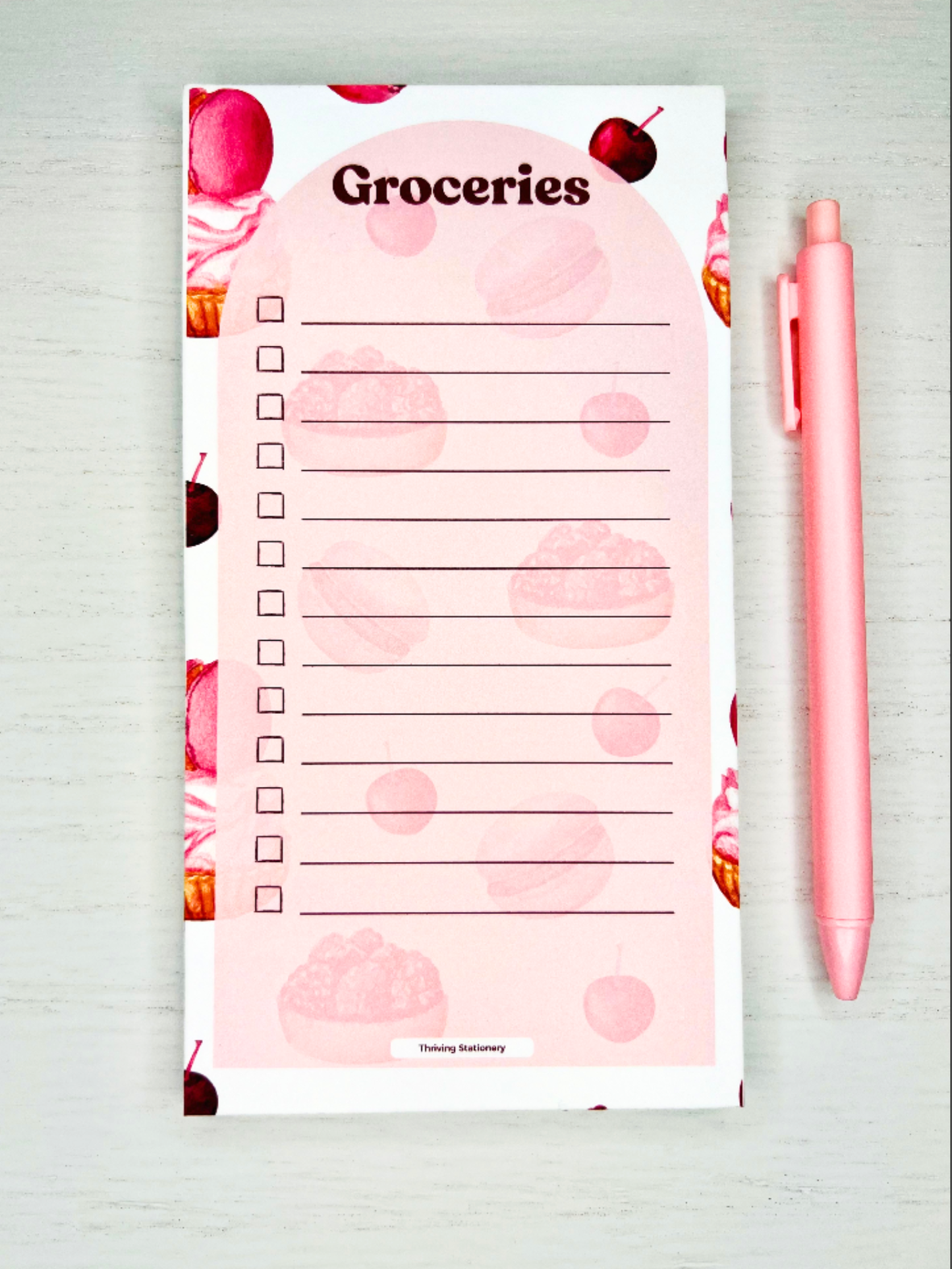 Sweet Treats Magnetic Grocery List Notepad with pink dessert illustrations and checkbox layout with a pen for scale