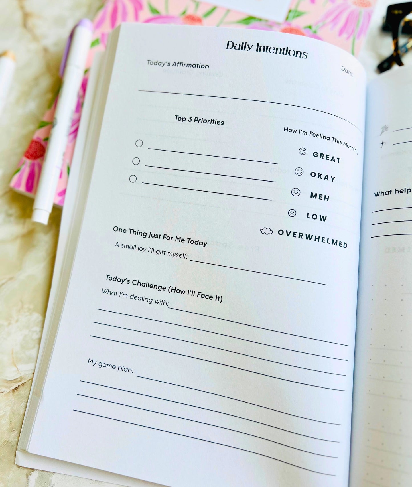Open planner with daily intentions section on a floral background