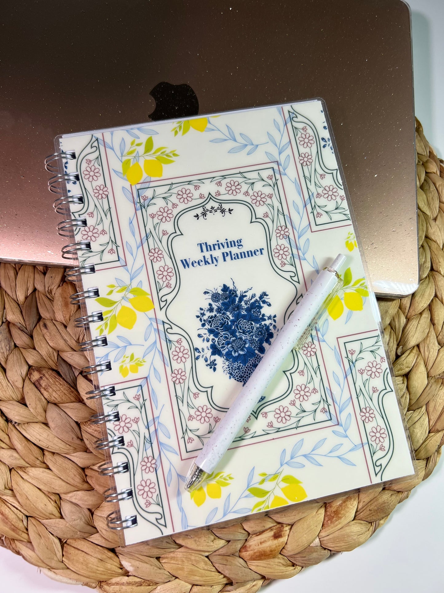 Thrive Weekly Planner with a pen on a woven mat