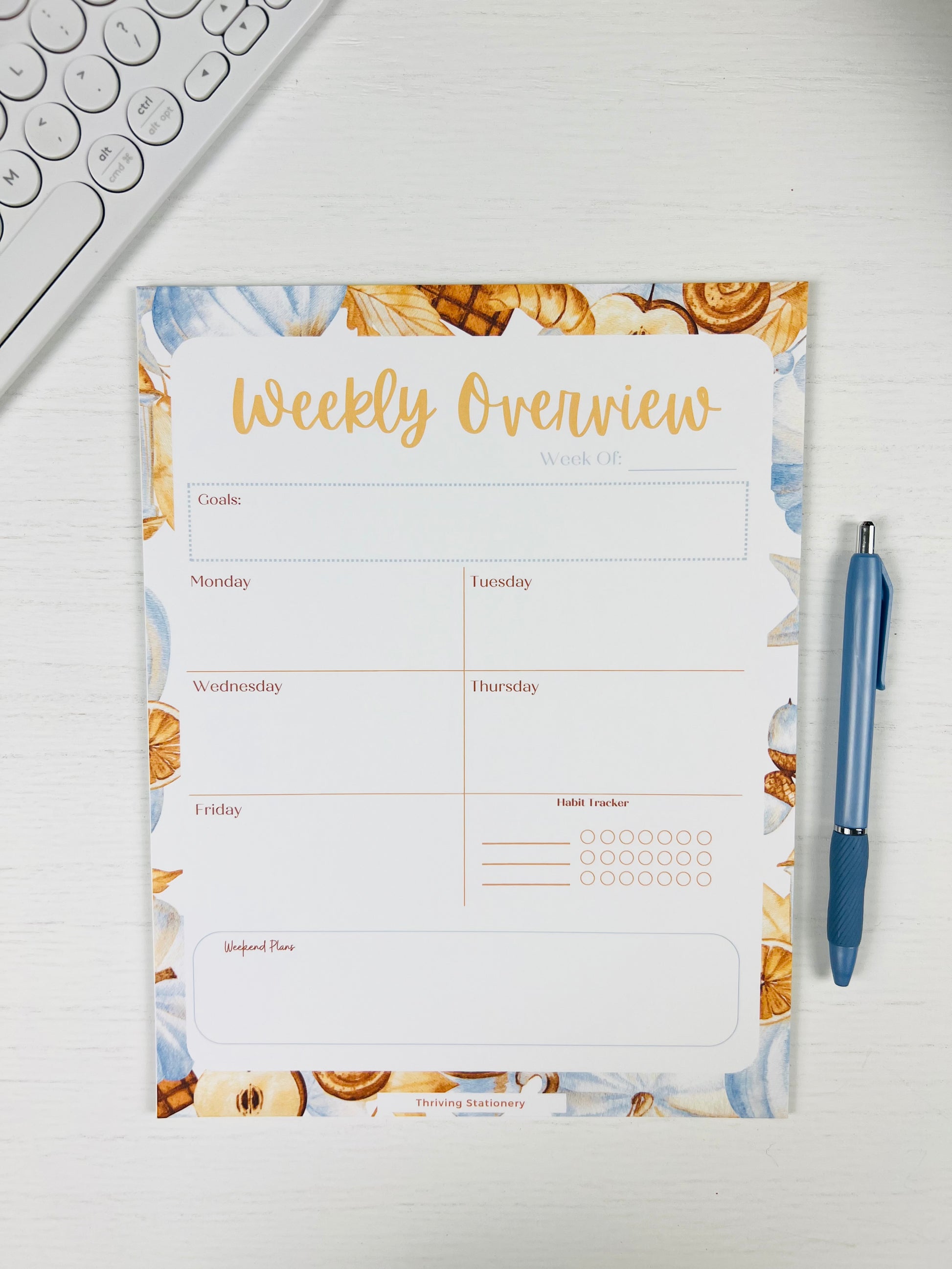 Warm & Cozy Weekly Planner Notepad with neutral cozy design and weekly layout with a pen for scale