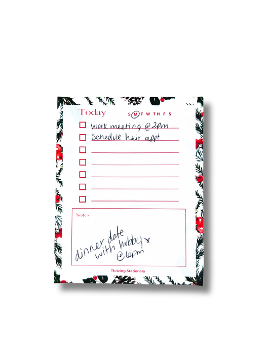 Notepad with a floral border and handwritten text on a white background